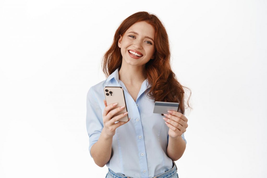 woman holding credit card and cellphone