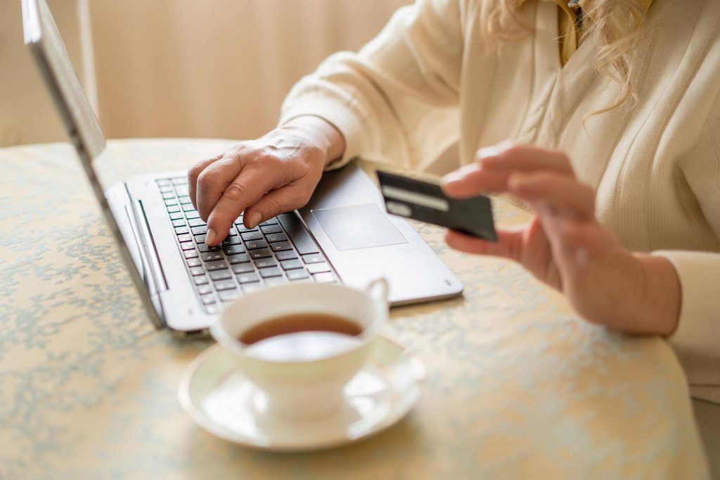 senior woman using credit card to buy online