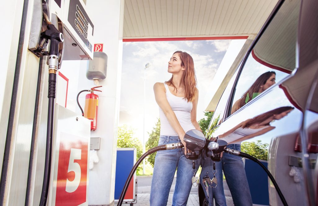 Pretty young woman refuel the car