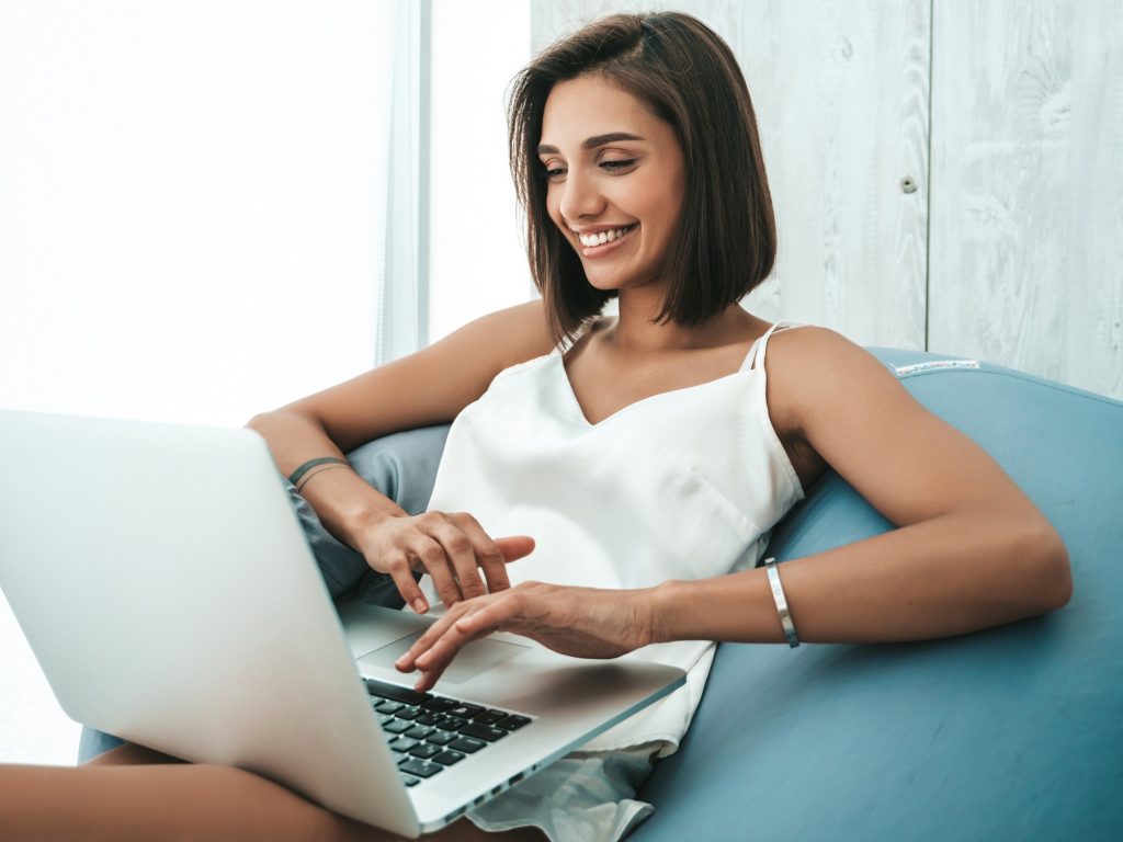 woman sitting on the couch using laptop 