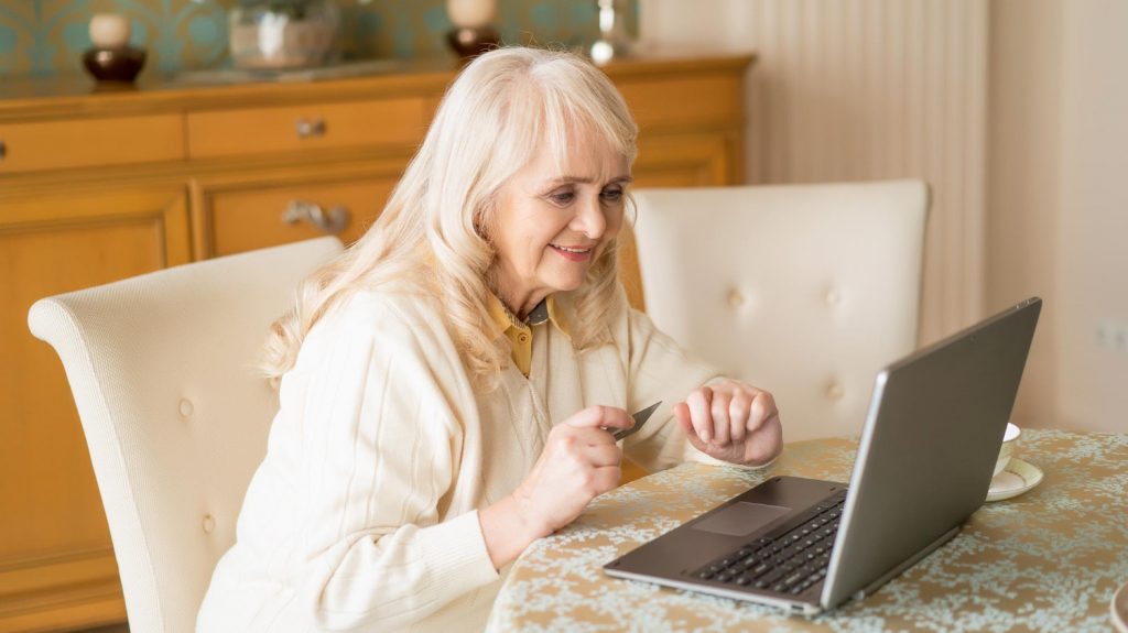 old lady using credit card and laptop