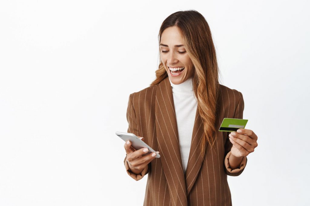 happy-corporate-woman-order-online-smartphone-app-holding-credit-card-smiling-mobile-phone-white-background