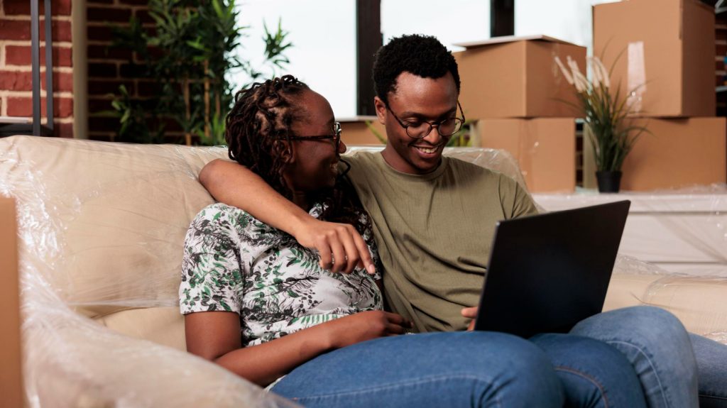 happy married couple using laptop to apply online for home improvement loan
