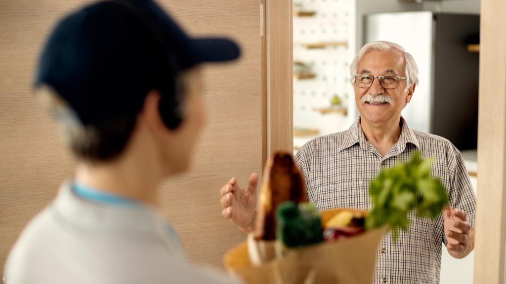 old man receiving groceries at home
