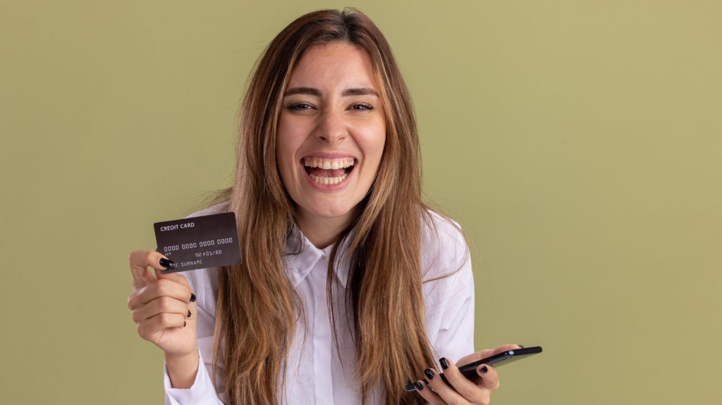 joyful young woman hold prepaid credit cards