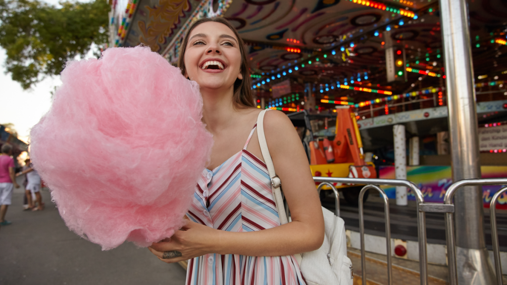young brunette woman smiling and holding cotton candy