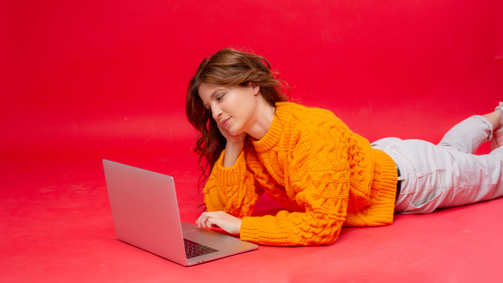 woman laying down and working on her laptop