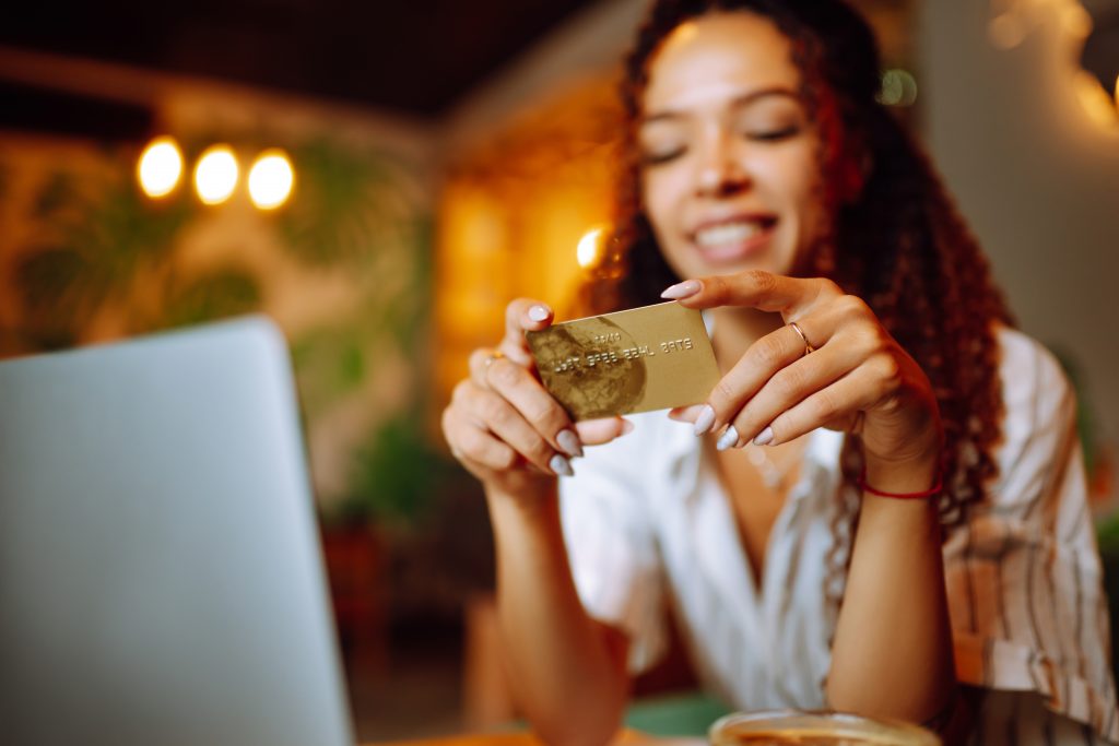 Female Hands holding credit card and using laptop. Young woman